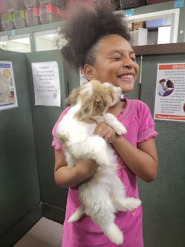 Child smiling while holding a puppy