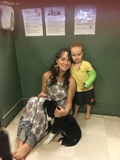Woman and child sitting with a puppy at Petland Leon Valley